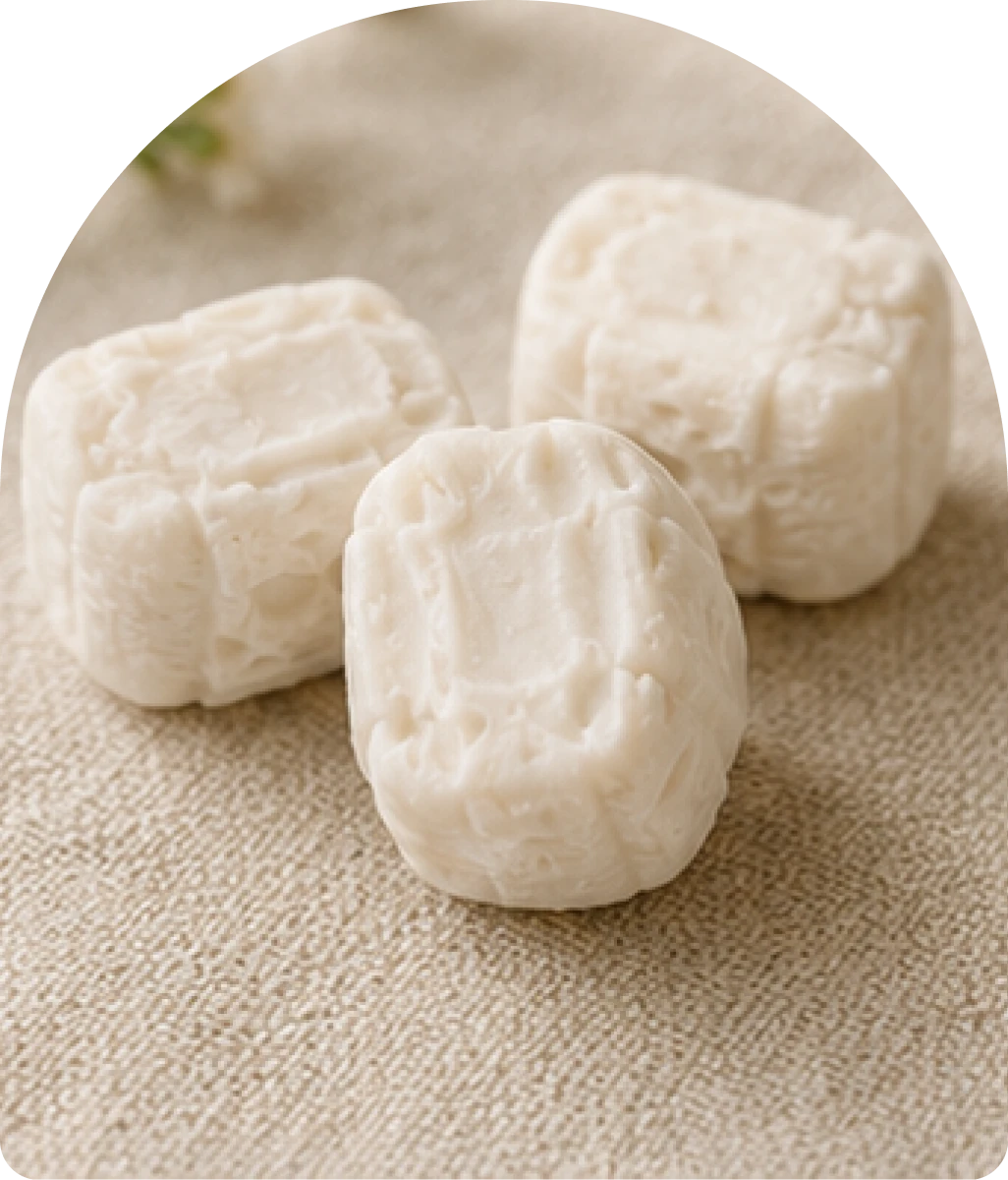 Three white cheese cubes on fabric